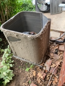 Outdoor AC unit covered in debris. 