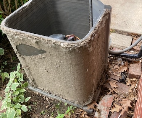 Outdoor AC unit covered in debris.